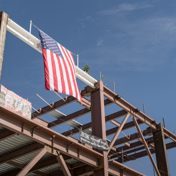 Flag on beam at Concourse A East Topping Out ceremony October 13 2021